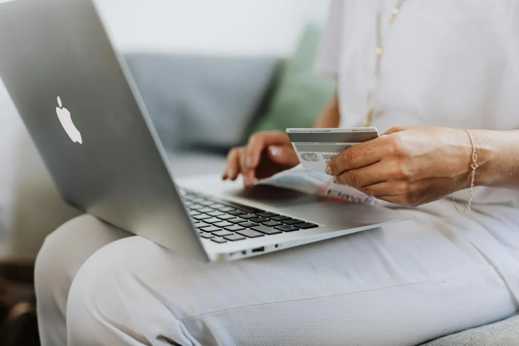 Persona realizando transferencias bancarias online con tarjeta de crédito.